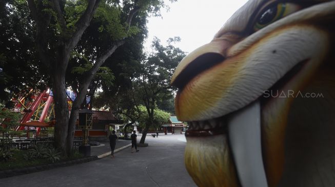 Pekerja melintas di sekitar wahana Dunia Fantasi (Dufan), Taman Impian Jaya Ancol, Jakarta, Sabtu (14/3). [Suara.com/Angga Budhiyanto] 