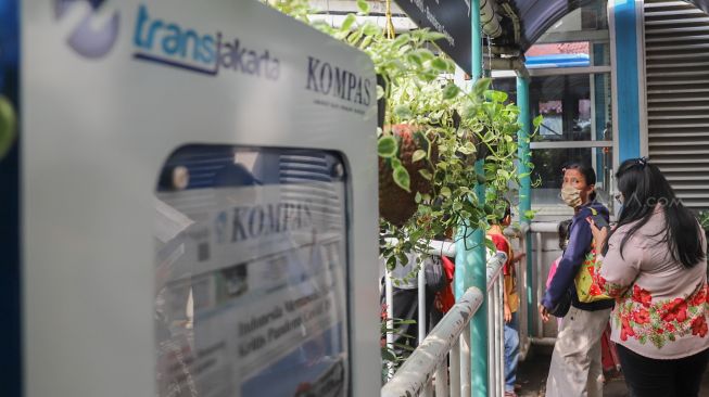 Penumpang antre didepan pintu masuk halte Transjakarta Pinang Ranti, Jakarta Timur, Senin (16/3). [Suara.com/Alfian Winanto]
