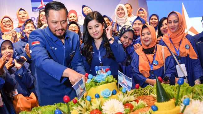 Ketua Umum Partai Demokrat yang baru, Agus Harimurti Yudhoyono (kiri) didampingi istri Annisa Pohan (kedua kiri) memotong tumpeng saat Kongres V Partai Demokrat di Jakarta, Minggu (15/3)