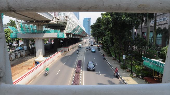 Kendaraan melintas di jalan Rasuna Said, Jakarta, Senin (16/3). [Suara.com/Alfian Winanto]