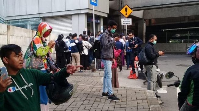 Antrean penumpang di halte MRT Duku Atas imbas kebijakan pembatasan angkutan umum di Jakarta mengantisipasi corona, Senin (16/3/2020). (Suara.com/Muhammad Yasir)