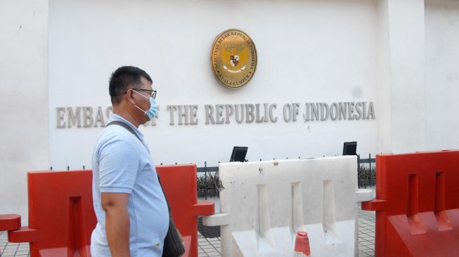 Seorang WNI berjalan di depan kantor Kedutaan Besar Republik Indonesia (KBRI) di Kuala Lumpur, Malaysia, Selasa (17/3).   [ANTARA FOTO/Rafiuddin Abdul Rahman]