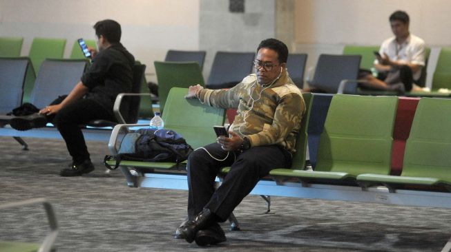 Calon penumpang menunggu jadwal keberangkatan pesawat di Terminal Keberangkatan Domestik Bandara Internasional I Gusti Ngurah Rai, Bali, Rabu (18/3).  [ANTARA FOTO/Fikri Yusuf]