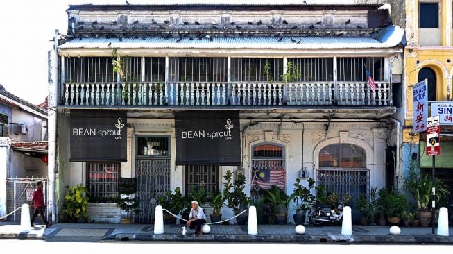 Seorang lelaki beristirahat di luar sebuah restoran tertutup di Penang, Malaysia, Rabu (18/3).  [GOH CHAI HIN / AFP]