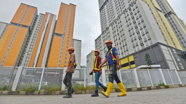 Sejumlah pekerja berjalan di kawasan Wisma Atlet, Kemayoran, Jakarta, Kamis (19/3).  [ANTARA FOTO/Aditya Pradana Putra]