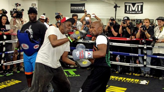 Legenda tinju dunia Floyd Mayweather Jr. (kanan) tengah berlatih bersama paman sekaligus pelatihnya, Roger Mayweather, di Mayweather Boxing Gym, Las Vegas, Amerika Serikat. [AFP/John Gurzinski]