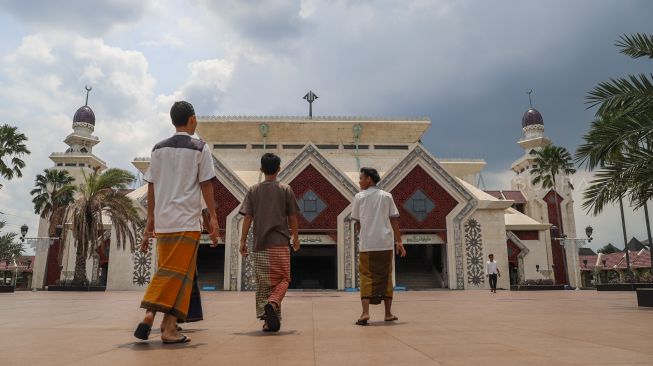 Umat muslim hendak beribadah Salat Zuhur berjamaah di Masjid Agung At-Tin, Taman Mini, Jakarta Timur, Jumat (20/3). [Suara.com/Alfian Winanto]