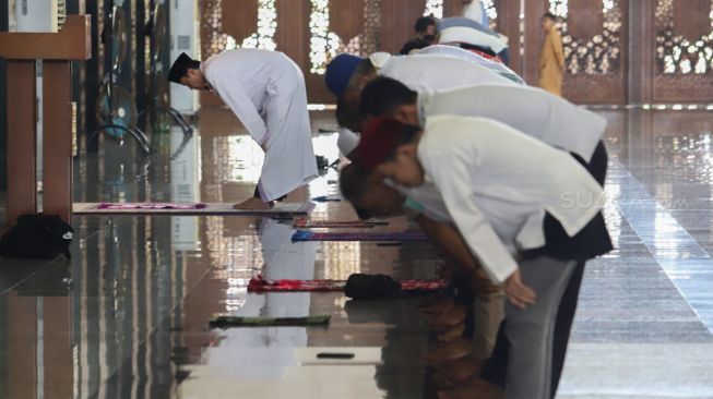 Umat muslim rukuk saat melaksanakan ibadah Salat Zuhur berjamaah di Masjid Agung At-Tin, Taman Mini, Jakarta Timur, Jumat (20/3). [Suara.com/Alfian Winanto]