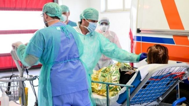 Situasi penanganan virus corona di salah satu rumah sakti di Italia, dokter mengenakan alat pelindung diri lengkap dan masker. (PIERO CRUCIATTI / AFP)