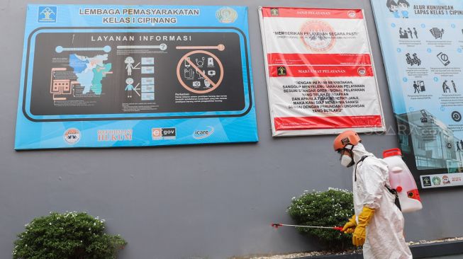 Petugas PMI menyemprotkan cairan disinfektan di halaman Lapas kelas 1 Cipinang, Jakarta Timur, Jumat (20/3). [Suara.com/Alfian Winanto]