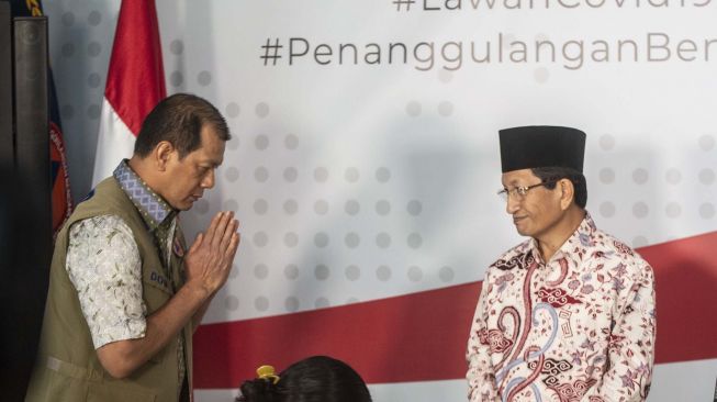 Ketua Gugus Tugas Percepatan Penanganan COVID-19 yang juga Ketua BNPB Doni Monardo (kiri) memberi salam Imam Besar Masjid Istiqlal Nasaruddin Umar (kanan) seusai memberikan keterangan pers terkait Fatwa MUI No 14 Tahun 2020 tentang Penyelanggaraan Ibadah dalam Situasi Terjadi Wabah COVID-19 di Graha BNPB, Jakarta, Jumat (20/3). [ANTARA FOTO/Aprillio Akbar]