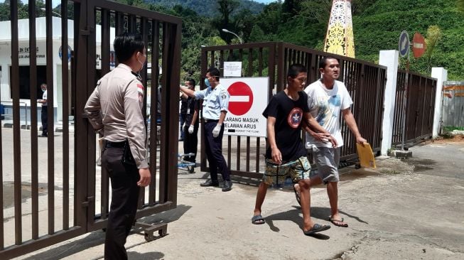 Sejumlah Pekerja Migran Indonesia (PMI) melintasi pintu pagar setibanya di Pos Lintas Batas Negara (PLBN) Entikong, Kabupaten Sanggau, Kalbar, Sabtu (21/3). [ANTARA FOTO/Agus Alfian]