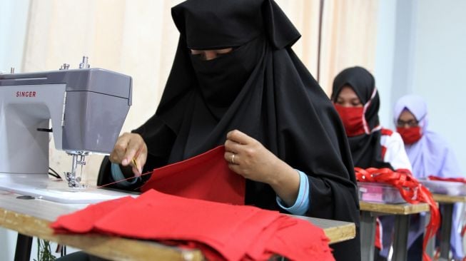 Sejumlah siswa alumni Pelatihan Bebasis Kompetensi (PBK) menjahit masker yang direncanakan dibagikan secara gratis untuk mengantisipasi penyebaran virus COVID-19 di Kantor Balai Latihan Kerja (BLK) Kendari, Sulawesi Tenggara, Minggu (22/3). [ANTARA FOTO/Jojon]