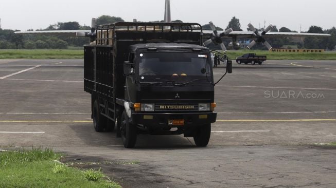 Truk yang membawa logistik kesehatan dari pesawat Hercules C-130 melintas meninggalkan Landasan Udara (Lanud) Halim Perdanakusuma, Jakarta, Senin (23/3). [Suara.com/Angga Budhiyanto]