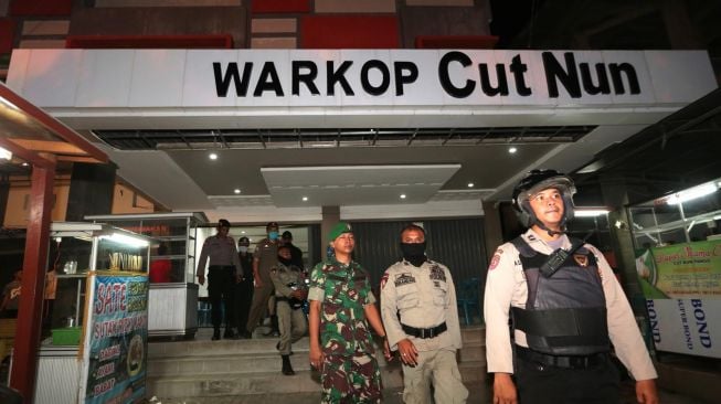 Tim gabungan yang terdiri dari Satpol PP dan Wilayatul Hisbah serta TNI/Polri mensosialisasikan kebijakan pemerintah daerah untuk menutup warung kopi di Banda Aceh, Aceh, Minggu (22/3) malam. Pemerintah Kota Banda Aceh menindaklanjuti surat Plt Gubernur Aceh yang meminta warung kopi, kafe, tempat karoeke, pantai wisata dan tempat-tempat keramaian agar ditutup sementara waktu sebagai salah satu upaya pencegahan penyebaran virus Corona (COVID-19).  [ANTARA FOTO/Irwansyah Putra]