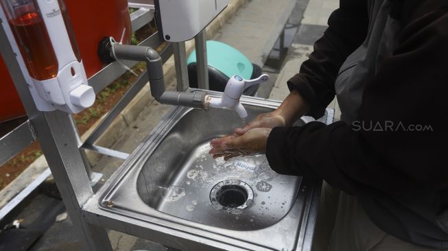 Warga mencuci tangan di fasilitas tempat mencuci tangan untuk umum di kawasan Senayan, Jakarta, Senin (23/3). [Suara.com/Angga Budhiyanto]