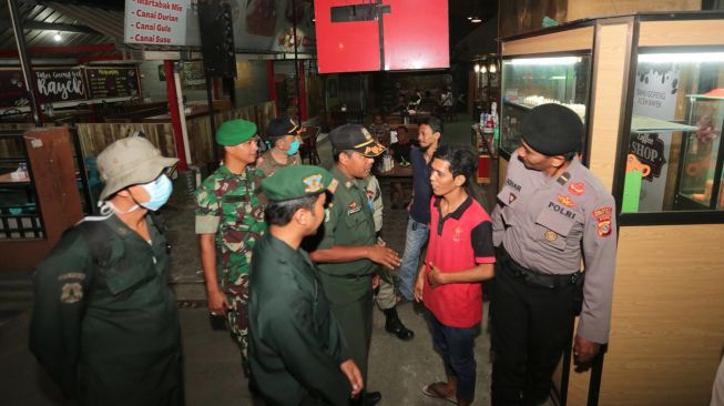 Tim gabungan yang terdiri dari Satpol PP dan Wilayatul Hisbah serta TNI/Polri mensosialisasikan kebijakan pemerintah daerah untuk menutup warung kopi di Banda Aceh, Aceh, Minggu (22/3) malam.  [ANTARA FOTO/Irwansyah Putra]
