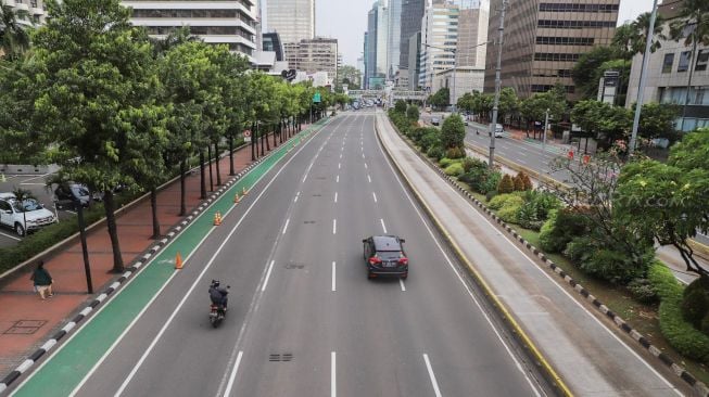 Kendaraan melintas di Jalan M. H Thamrin, Jakarta, Selasa (24/3). [Suara.com/Alfian Winanto]
