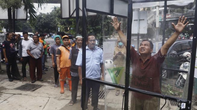 Sejumlah warga mengantre untuk menjajal alat Disinfection Chamber di kawasan Blok M, Jakarta Selatan, Selasa (24/3). [Suara.com/Angga Budhiyanto]