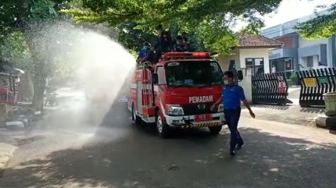 Mobil Damkar digunakan untuk menyemprotkan cairan disinfektan di sekitar obkjek wisata laut Palabuhanratu, Kabupaten Sukabumi, Jabar [ANTARA/Aditya Rohman].