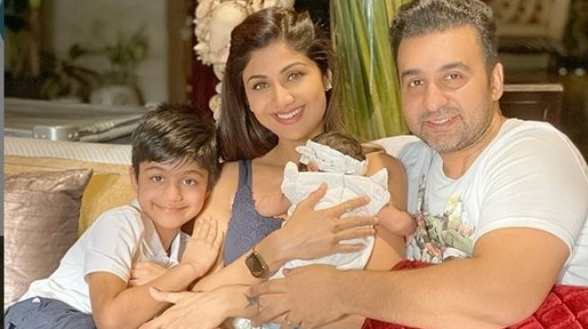 Shilpa Shetty menggendong banyinya, Samisha bersama suami, Raj Kundra dan anak pertamanya, Viaan Raj Kundra. [Instagram]