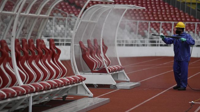 Petugas menyemprotkan cairan disinfektan ke kursi pemain di Kompleks Stadion Utama Gelora Bung Karno (SUGBK), Senayan, Jakarta, Kamis (26/3).  [ANTARA FOTO/Puspa Perwitasari]