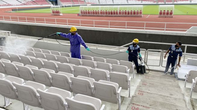 Petugas menyemprotkan cairan disinfektan ke bangku penonton di Kompleks Stadion Utama Gelora Bung Karno (SUGBK), Senayan, Jakarta, Kamis (26/3).  [ANTARA FOTO/Puspa Perwitasari]