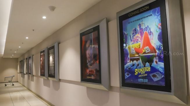 Lorong berisi poster film yang terlihat sepi di mall Jatinegara City Plaza, Jakarta Timur, Kamis (26/3). [Suara.com/Alfian Winanto]