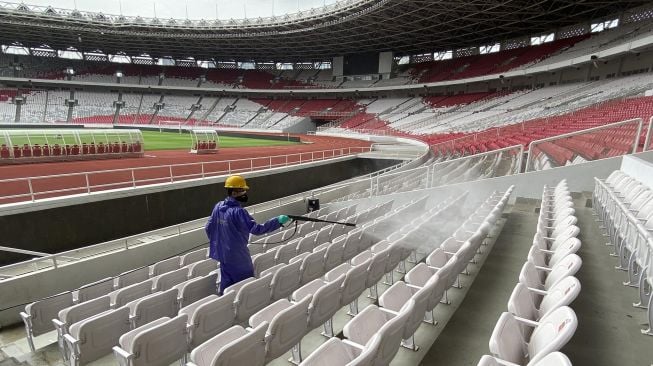 Petugas menyemprotkan cairan disinfektan di Kompleks Stadion Utama Gelora Bung Karno (SUGBK), Senayan, Jakarta, Kamis (26/3).  [ANTARA FOTO/Puspa Perwitasari]