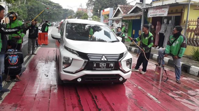 Ojol di Lebak Ramai-ramai Desinfeksi Kendaraan di Jalan Hardiwinangun
