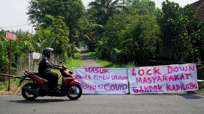 Suasana di dekat akses masuk kampung yang ditutup di kawasan Pakem, Sleman, D.I Yogyakarta, Jumat (27/3). [ANTARA FOTO/Andreas Fitri Atmoko]