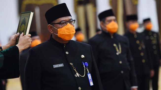 Aparatur Sipil Negara (ASN) eselon III dan IV disumpah dengan Al-quran saat mengikuti pengambilan sumpah jabatan di Gedung Negara Grahadi, Surabaya, Jawa Timur, Jumat (27/3).  [ANTARA FOTO/Zabur Karuru]