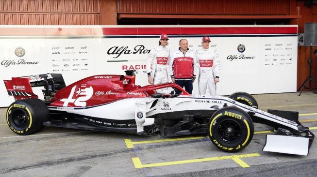 Bos Tim F1 Alfa Romeo Frederic Vasseur diapit kedua pebalapnya Kimi Raikkonen (kanan) dan Antonio Giovinazzi pada peluncuran mobil untuk Formula 1 2019 di Sirkuit Catalunya, Spanyol, Senin (18/2/2019). [AFP/Lluis Gene]