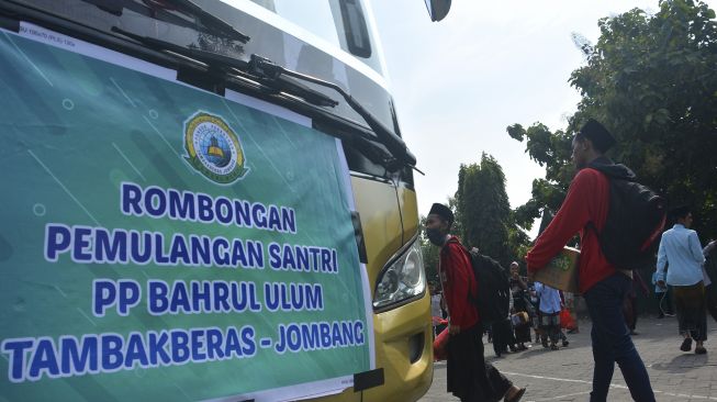 Santri menuju ke dalam bus saat pemulangan santri di Pondok Pesantren Bahrul Ulum Tambakberas, Jombang, Jawa Timur, Sabtu (28/3). [ANTARA FOTO/Syaiful Arif]