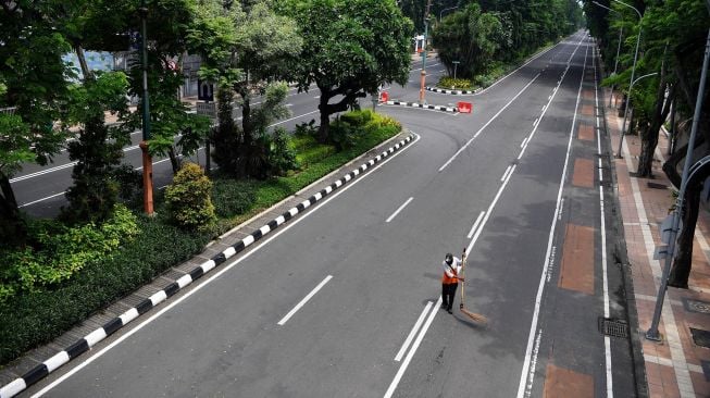 Petugas kebersihan menyapu jalan di Jalan Darmo yang ditutup, Surabaya, Jawa Timur, Sabtu (28/3).  [ANTARA FOTO/Zabur Karuru]