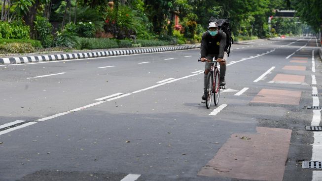 Pesepeda melintas di Jalan Darmo yang ditutup, di Surabaya, Jawa Timur, Sabtu (28/3). [ANTARA FOTO/Zabur Karuru]
