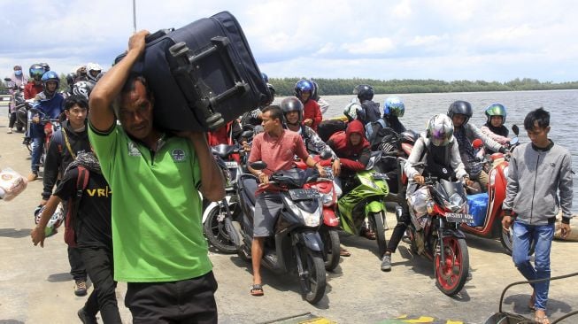 Sejumlah calon penumpang bersiap memasuki Kapal Motor Penyeberangan (KMP) Teluk Sinabang di Pelabuhan Penyeberangan Meulaboh-Sinabang Desa Gampong Teungoh, Samatiga, Aceh Barat, Aceh, Sabtu (28/3). [ANTARA FOTO/Syifa Yulinnas]