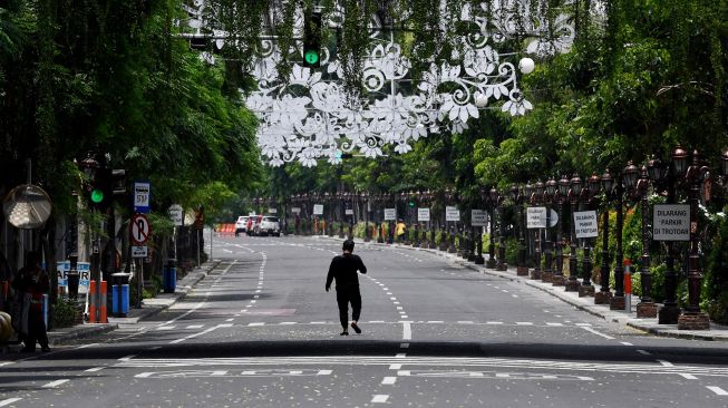 Warga melintas di Jalan Tunjungan yang ditutup, di Surabaya, Jawa Timur, Sabtu (28/3). [ANTARA FOTO/Zabur Karuru]
