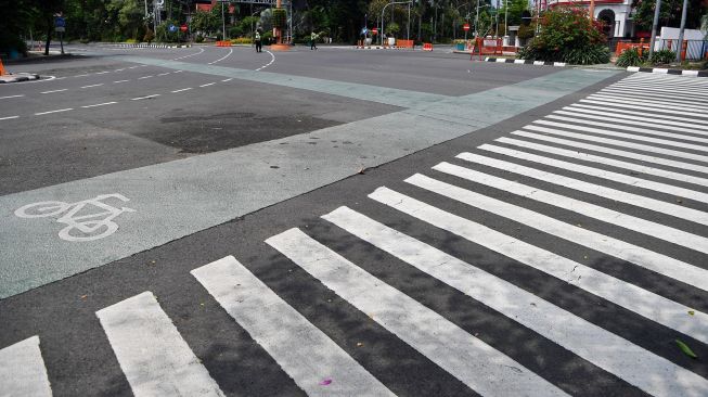 Polisi berjaga di Jalan Darmo yang ditutup, di Surabaya, Jawa Timur, Sabtu (28/3). [ANTARA FOTO/Zabur Karuru]
