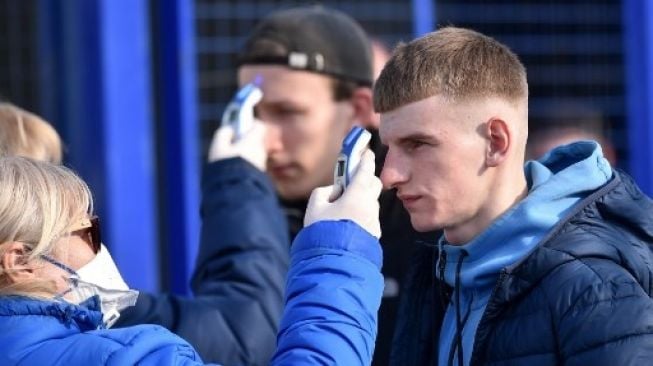 Suporter di Liga Belarusia mendapat pemeriksaan suhu tubuh sebelum memasuki stadion. (Sergei Gapon/AFP).