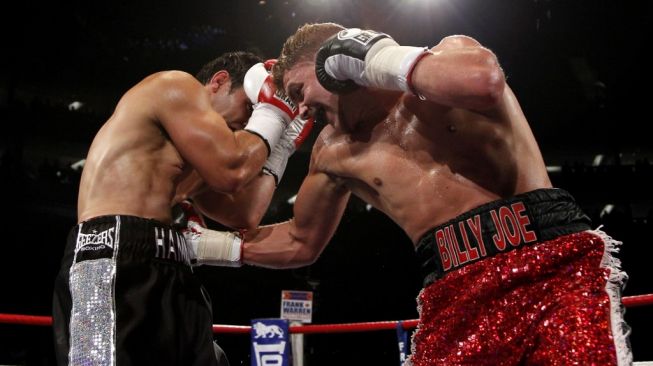 Petinju Inggris, Billy Joe Saunders (kanan), mendaratkan pukulan ke perut kompatriotnya Kevin Hammond dalam pertarungan kelas menengah di O2 Arena, London, Inggris, Sabtu (21/5/2011). [AFP/Ian Kington]