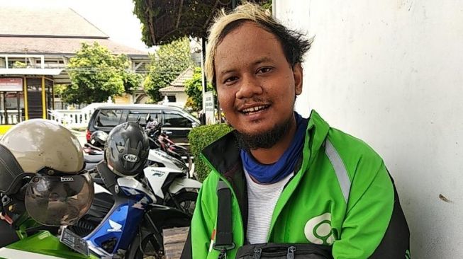 Driver ojol Dannies Mutiara Adi berbagi kisah tentang pekerjannya di tengah wabah COVID-19, Selasa (31/3/2020), di Jalan Gedong Kuning, Kotagede, Yogyakarta. - (SuaraJogja.id/Muhammad Ilham Baktora)