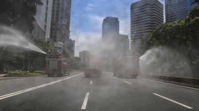 Penyemprotan cairan disinfektan di sepanjang jalan Jenderal Sudirman-MH Thamrin, Jakarta, Selasa (31/3).  [ANTARA FOTO/Muhammad Adimaja]