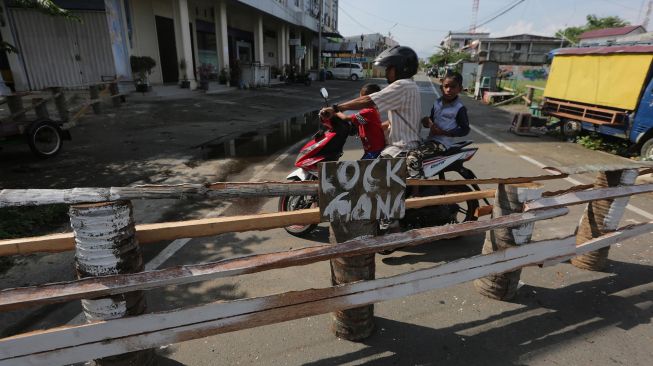 Pengendara motor berbalik arah karena jalan dan lorong akses masuk ke permukiman warga ditutup sementara di Banda Aceh, Aceh, Selasa (31/3).  [ANTARA FOTO/Irwansyah Putra]
