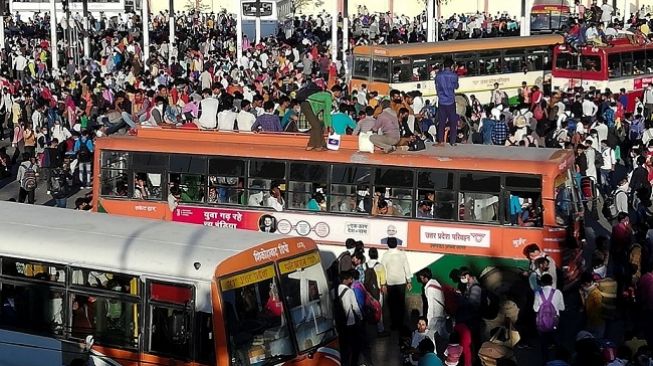 Suasana penuh sesak dengan manusia di Terminal Anand Vihar, New Delhi, India menjelang detik-detik pengumuman lockdown akibat wabah virus corona. (Foto: AFP)