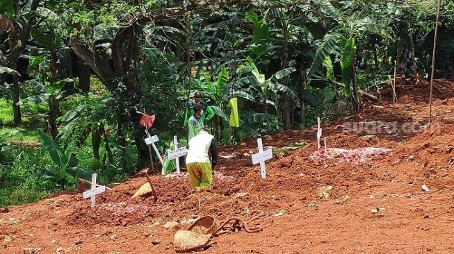 Penggali kubur di TPU Pondok Ranggon saat memakamkan jenazah positif corona. (Suara.com/Bagaskara Isdiansyah).