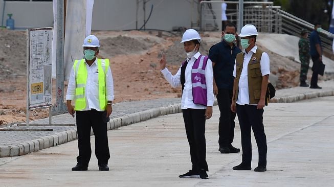 Presiden Joko Widodo (tengah) berbincang dengan Kepala BNPB Doni Monardo (kanan) dan Menteri PUPR Basuki Hadimuljono saat peninjauan Rumah Sakit Darurat Penanganan COVID-19 di Pulau Galang, Batam, Kepulauan Riau, Rabu (1/4). [ANTARA FOTO/Sigid Kurniawan]
