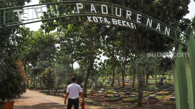 Petugas memasuki area Tempat Pemakaman Umum (TPU) Pasunderan yang ditunjuk sebagai tempat pemakaman pasien terjangkit virus Corona di Bekasi, Jawa Barat, Rabu (1/4). [Suara.com/Alfian Winanto]