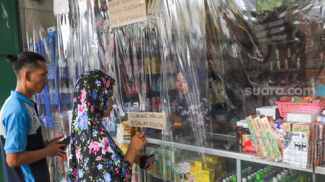 Pegawai toko melayani pembeli di toko kebutuhan balita di di Jalan Nusantara, Depok, Jawa Barat, Kamis (2/4). [Suara.com/Alfian Winanto]