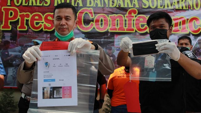 Kapolres Bandara Soetta Kombes Pol Adi Ferdiyan Saputra (kiri) didampingi Kasatreskrim Kompol Ahmad Alexander (kanan) menunjukan barang bukti kejahatan usai memberikan keterangan pers terkait pengungkapan kasus penipuan penjualan masker, di Mapolres Bandara Soekarno Hatta, Tangerang, Banten, Rabu (1/4).   [ANTARA FOTO/Muhammad Iqbal]